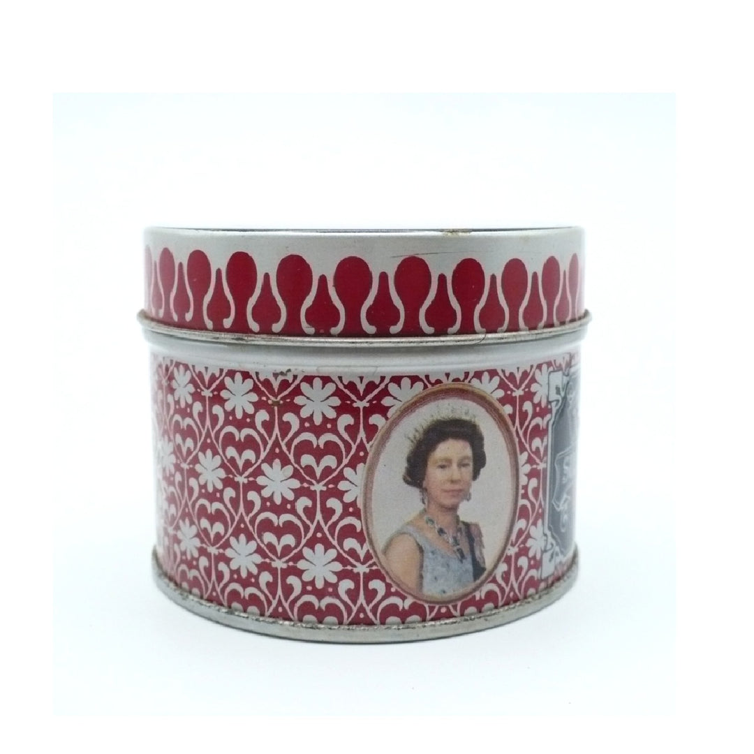 A vintage round metal Matchbox Tin with a red and white floral pattern, featuring an oval portrait of Queen Elizabeth on the front and a red teardrop motif around the rim.