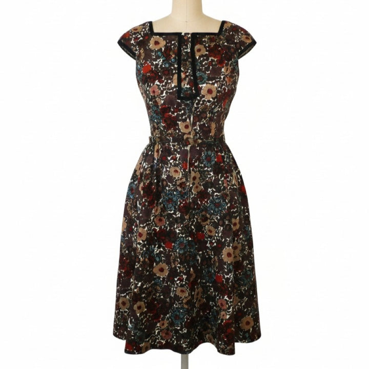 Vintage 1960s Shannon Rodgers cotton piqué day dress in dark brown with a multi-color floral print on a dress form.