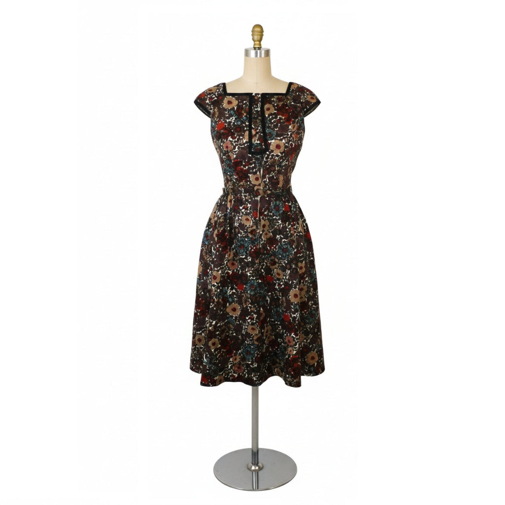Vintage 1960s Shannon Rodgers cotton piqué day dress in dark brown with a multi-color floral print on a dress form. showing full stand for scale.