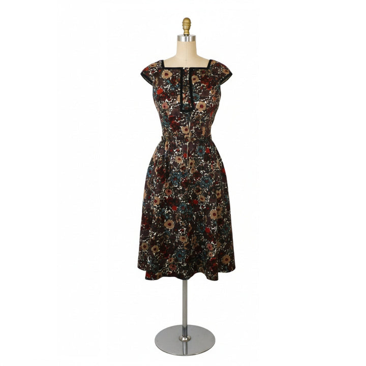 Vintage 1960s Shannon Rodgers cotton piqué day dress in dark brown with a multi-color floral print on a dress form. showing full stand for scale.