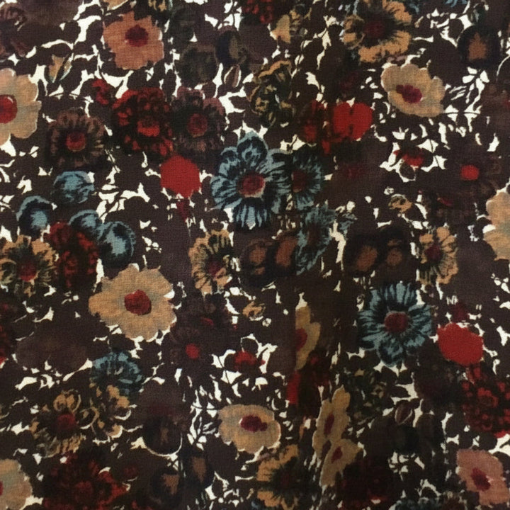 Close-up of the textured brown cotton piqué fabric with red and teal floral print.