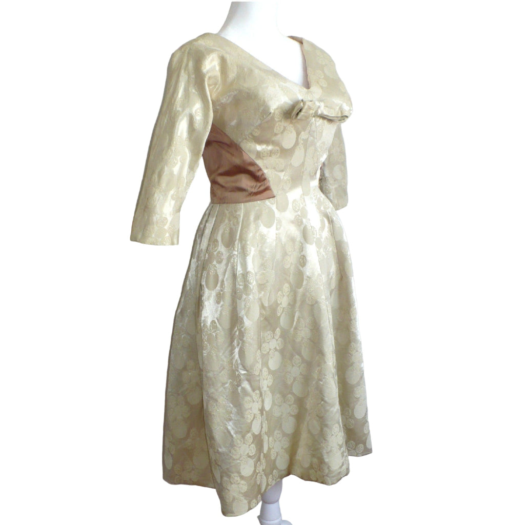 Side profile view of the 1960s vintage champagne white dress highlighting the Dolman sleeves and fitted waist.