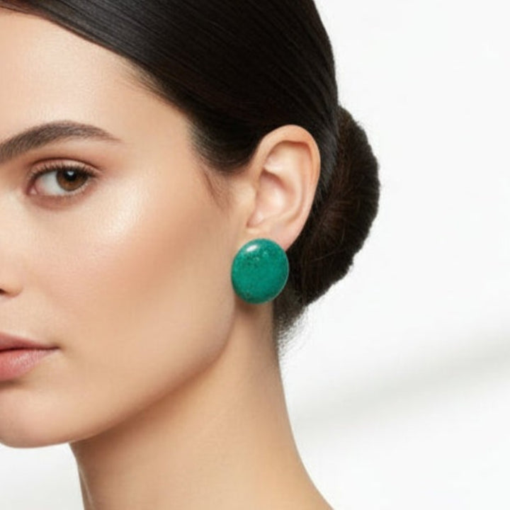 Close-up of a woman wearing Big 1980s Vintage Round Chrysocolla Gemstone Clip-on Statement Earrings  with a plain background