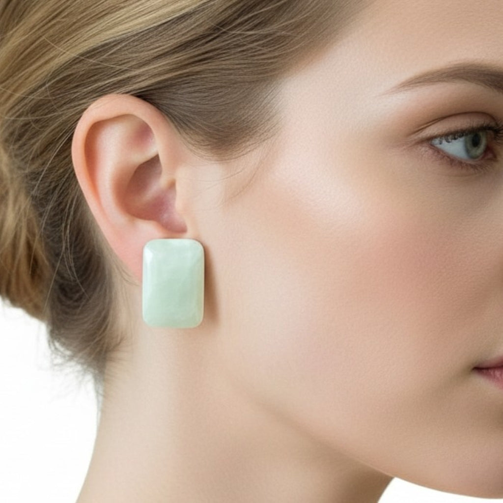 Close-up of a woman wearing 1980s Vintage Large Mother of Pearl Shell Cabochon Statement Earrings.
