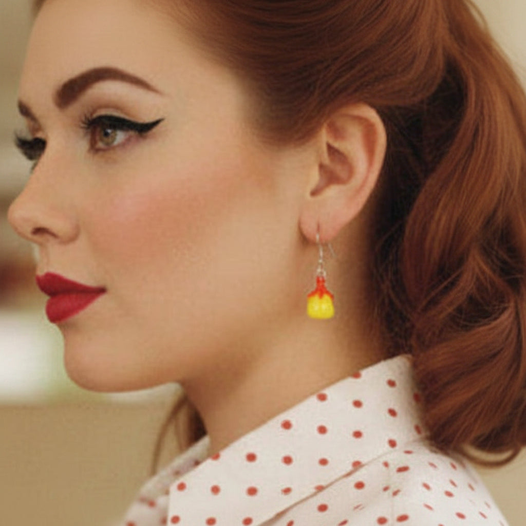Woman with vintage hairstyle and makeup wearing a polka dot blouse and fruity earrings.
