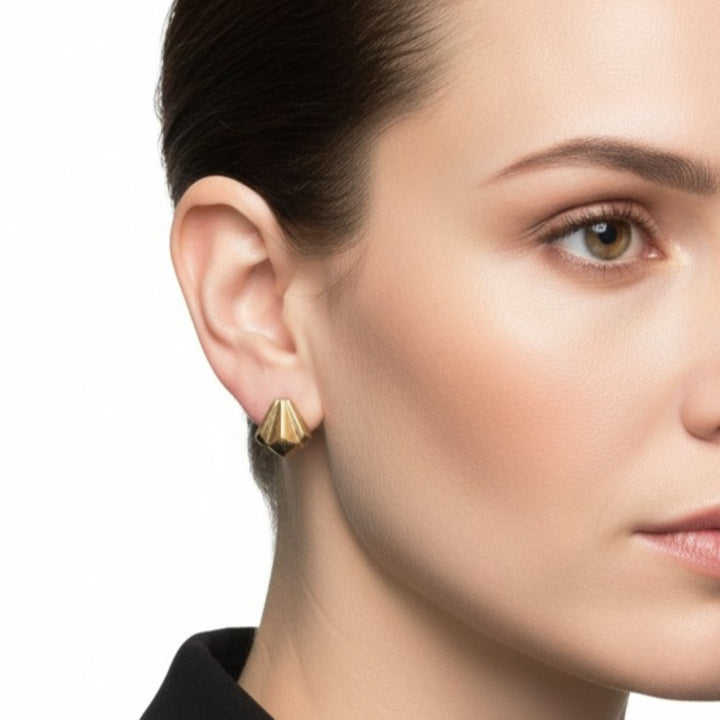 Close-up of a woman wearing 1940s Vintage Machine Age Screw-back Earrings, Art Deco by Jaycraft with a plain background.