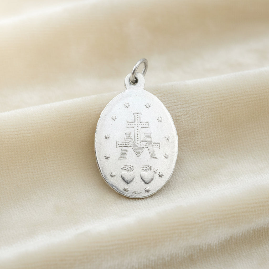 1940s Vintage WWII Eloxal Aluminum Miraculous Medal Pendant on cream velvet background, reverse view.