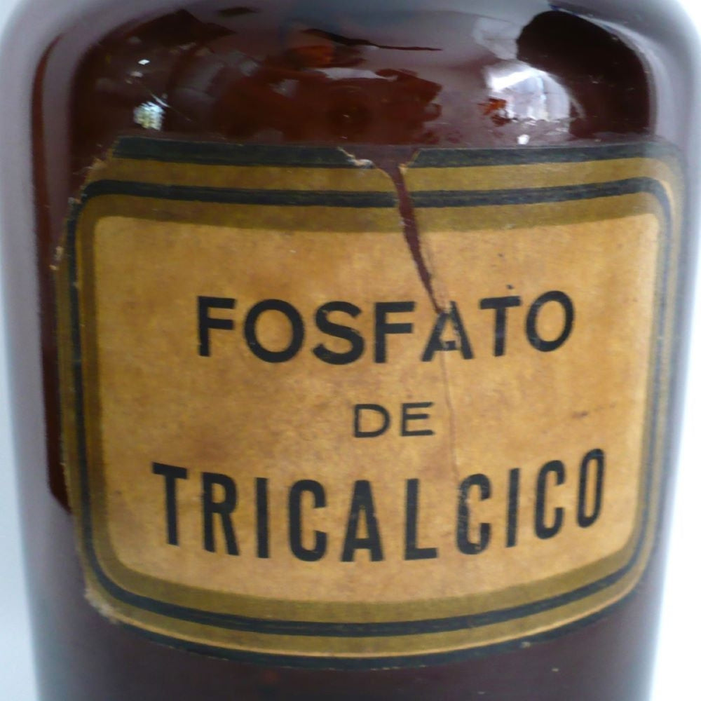 Close-up of the original paper lithographed label reading FOSFATO DE TRICALCICO with an ochre yellow border and Art Deco pinstripe design. on 1930 Amber Fosfato de Tricalcico Apothecary Jar