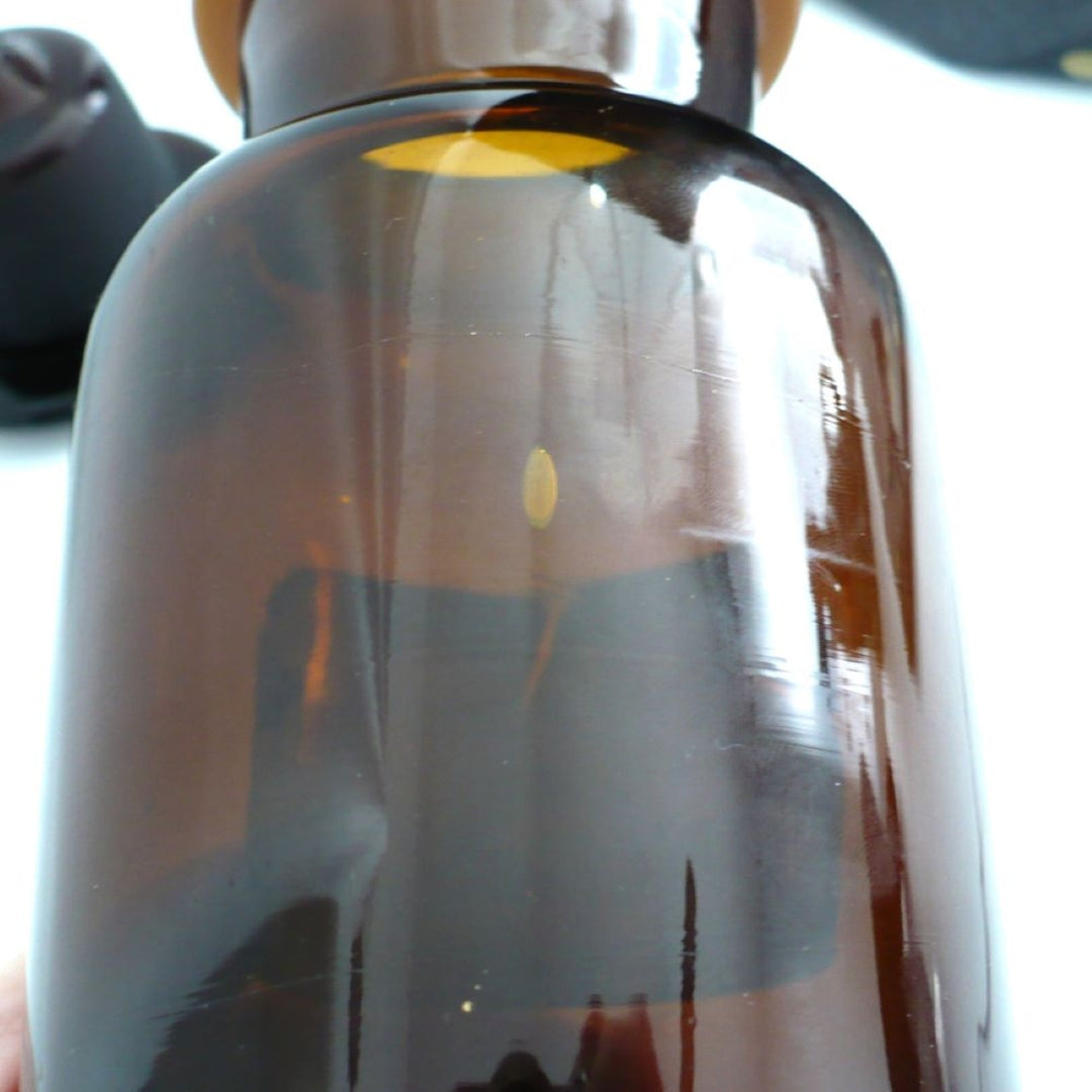 A close-up of gas bubbles in 1930 Amber Fosfato de Tricalcico Apothecary Jar.