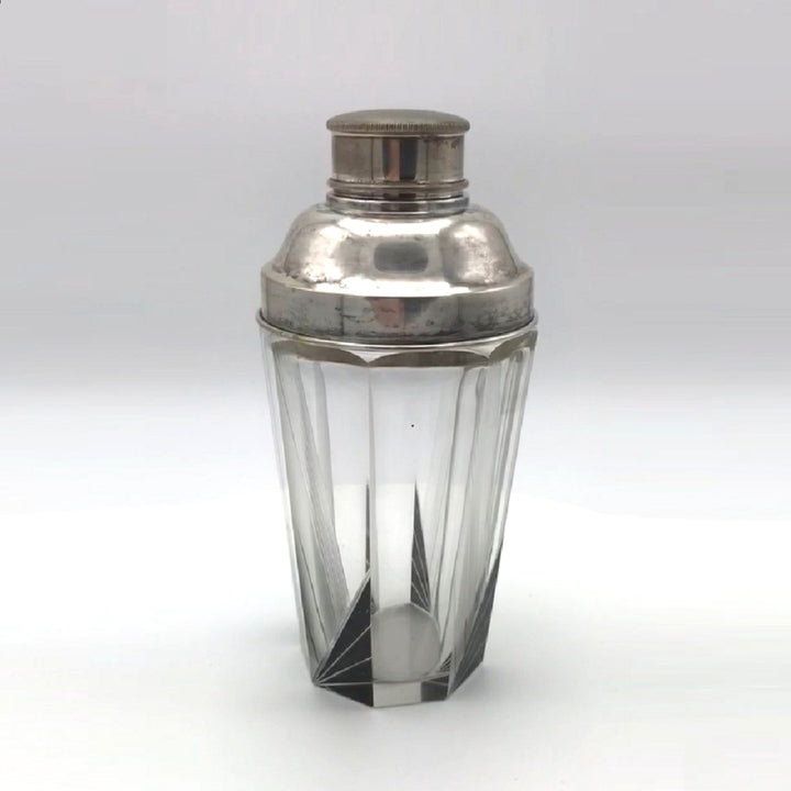 A vintage 1930s Karl Palda Art Deco Crystal Cocktail Shaker Czechoslovakia with a faceted clear crystal body, black enamel accents, and a polished silver metal lid, shown on a neutral light gray background.