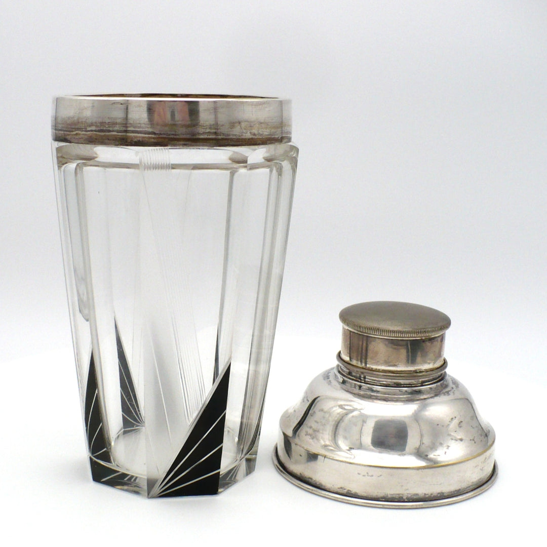 A vintage 1930s Karl Palda Art Deco Crystal Cocktail Shaker Czechoslovakia with a faceted clear crystal body, black enamel accents, and a polished silver metal lid shown removed and by its side.