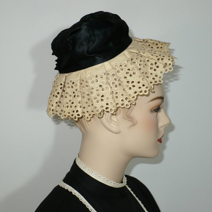 Side profile view of antique Victorian housemaid mobcap showing the lace ruffle and crown shape.