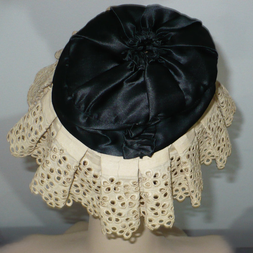 Back view of 1890s-1910s black silk and lace maid mobcap hat while worn.