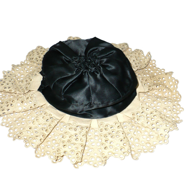 Flat lay view of antique Edwardian lady's maid cap showcasing the round black crown and gathered lace.