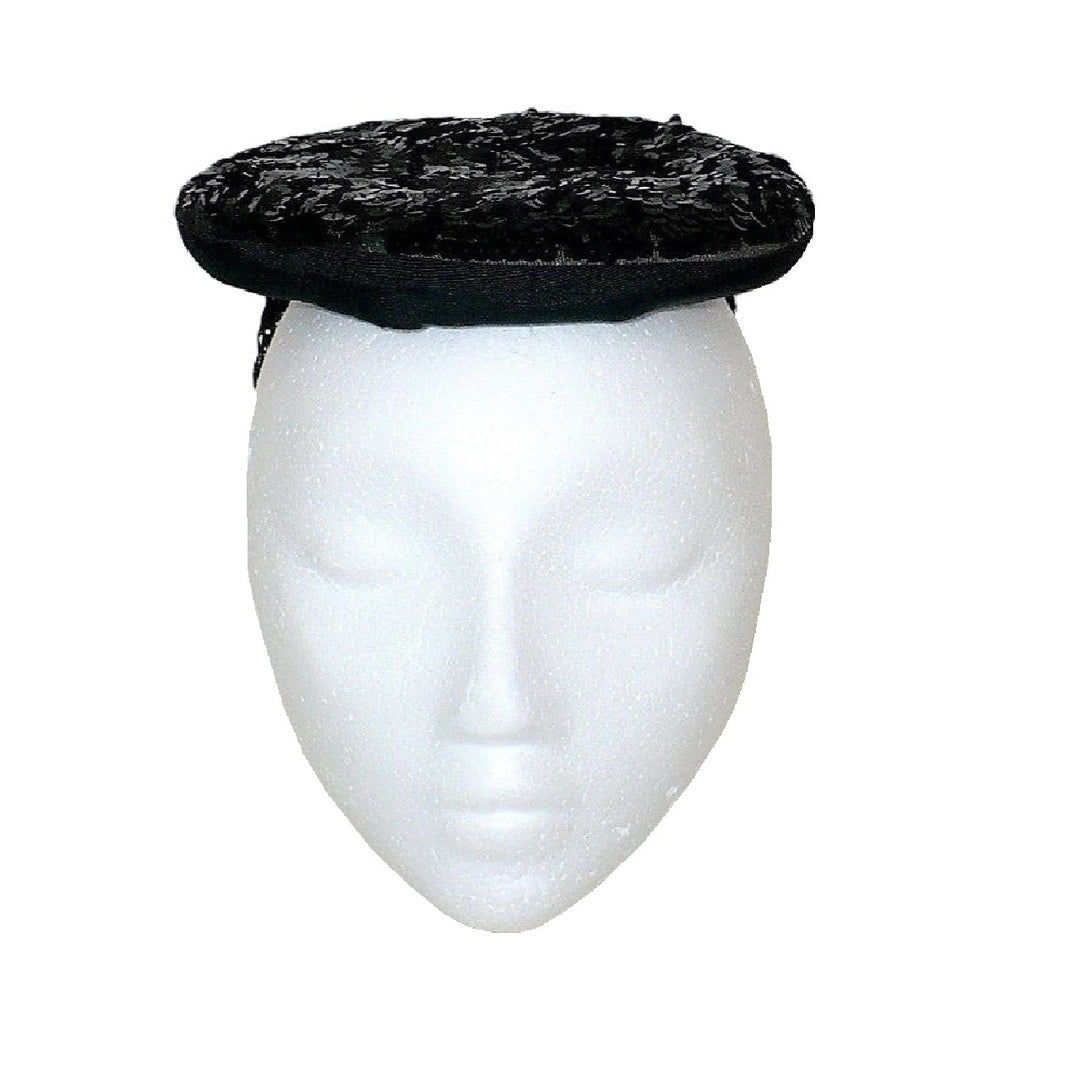 1930s black gelatin sequined percher hat worn on a white mannequin head, viewed from the front.