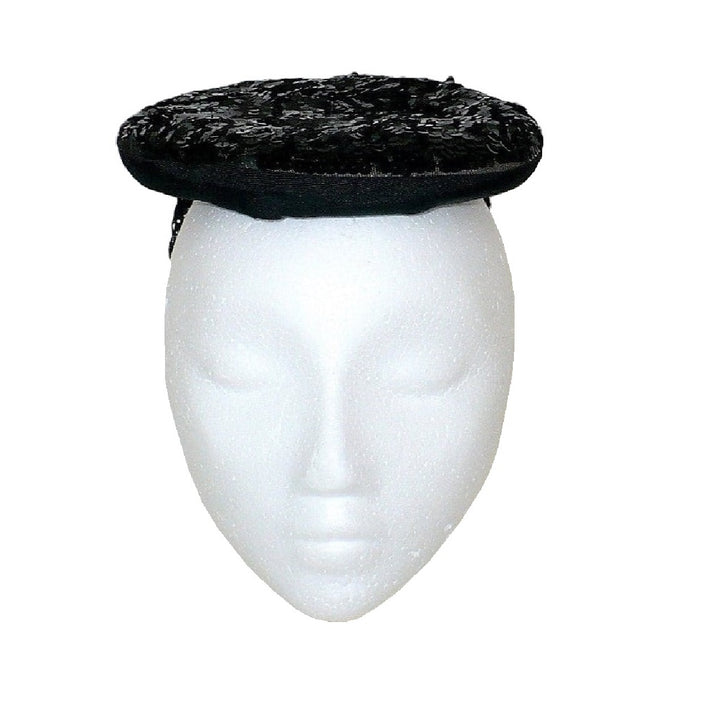 1930s black gelatin sequined percher hat worn on a white mannequin head, viewed from the front.