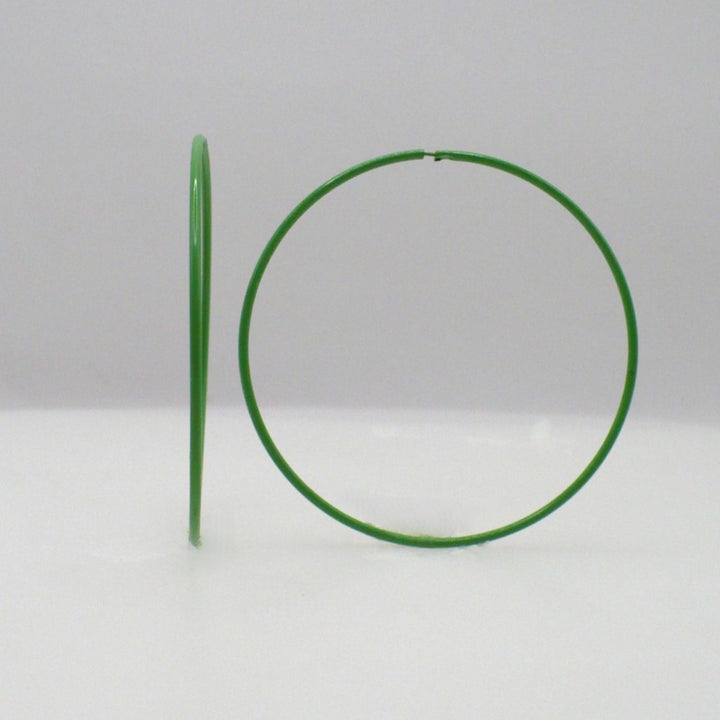 1980s kelly green pop art Memphis style 2-inch hoop earrings shown side-on and front-facing against a neutral white background.