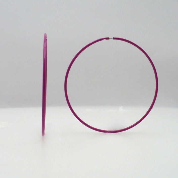 1980s pink pop art Memphis style 2-inch hoop earrings shown side-on and front-facing against a neutral white background.
