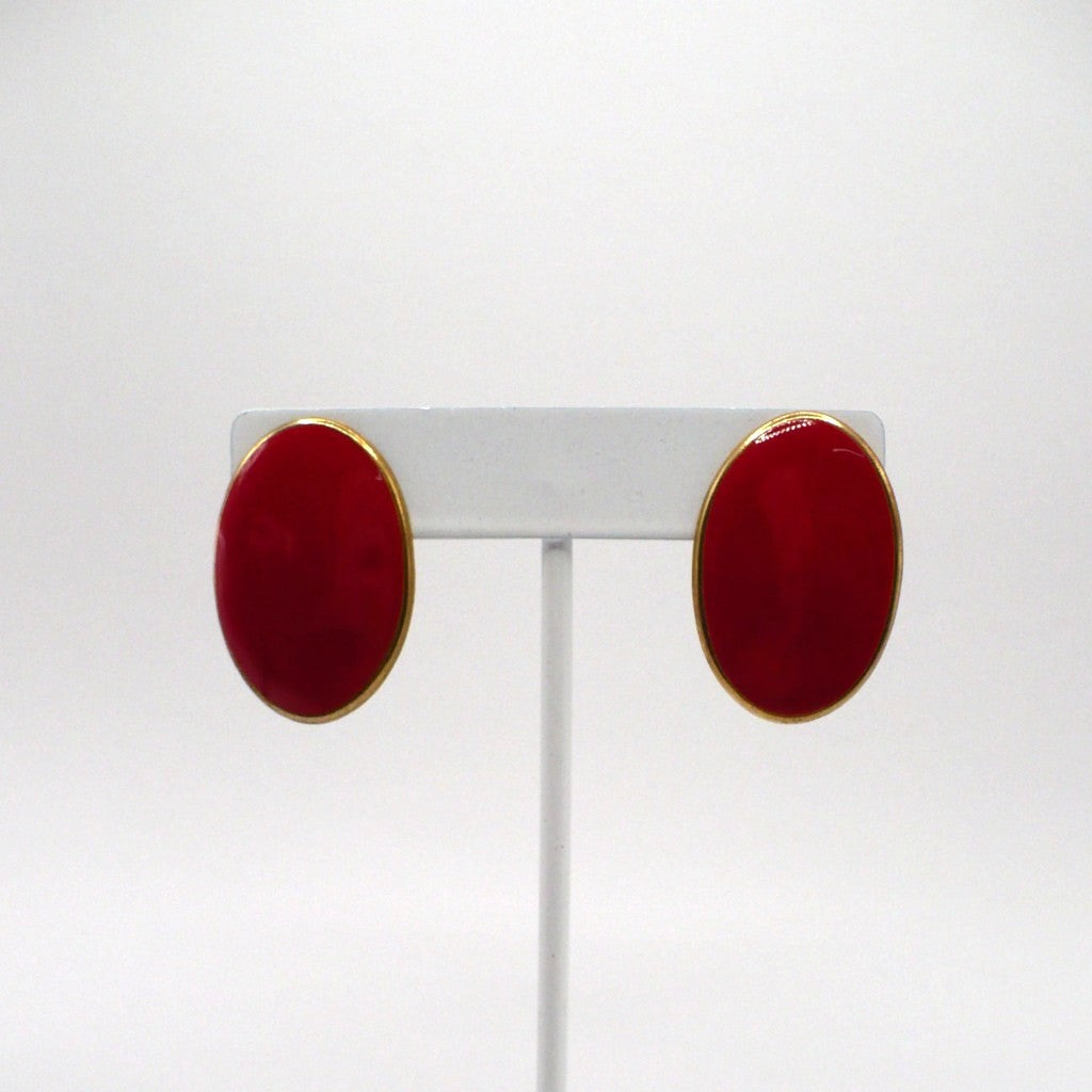 1980s vintage lipstick-red oval statement earrings with gold-tone outlines displayed on a white T-bar stand.
