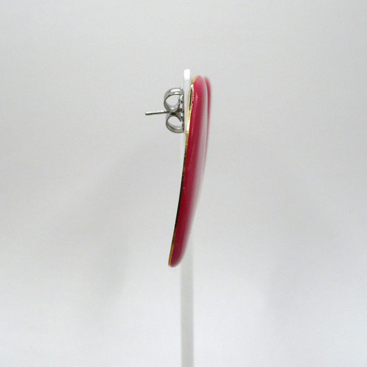 Close-up of 1980s vintage watermelon-pink marbled Lucite barrel earrings, side view