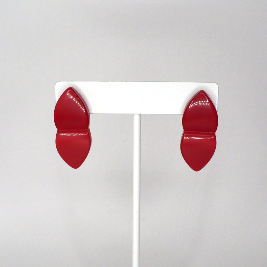 Close-up front view of translucent red acrylic split-design earrings showcasing their glossy finish and symmetrical shape.