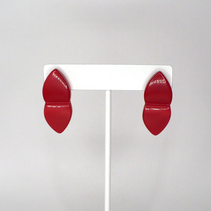 Close-up front view of translucent red acrylic split-design earrings showcasing their glossy finish and symmetrical shape.