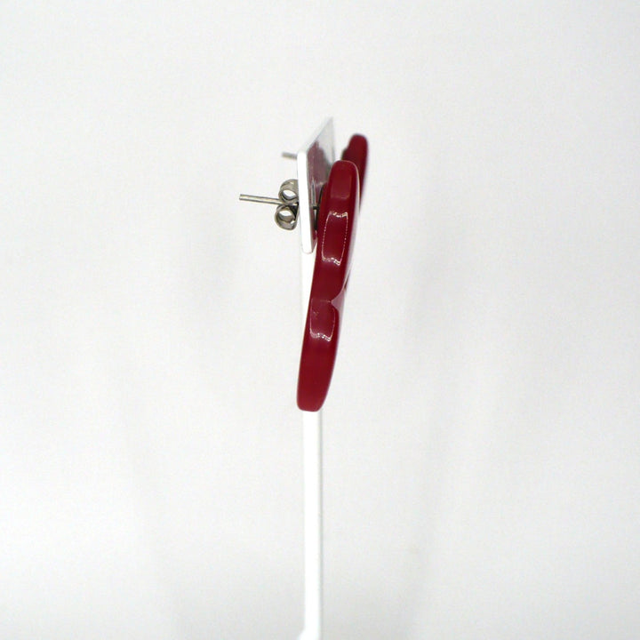 Side profile view of a vintage 1980s watermelon red Lucite geometric statement earring showing the post back and depth.
