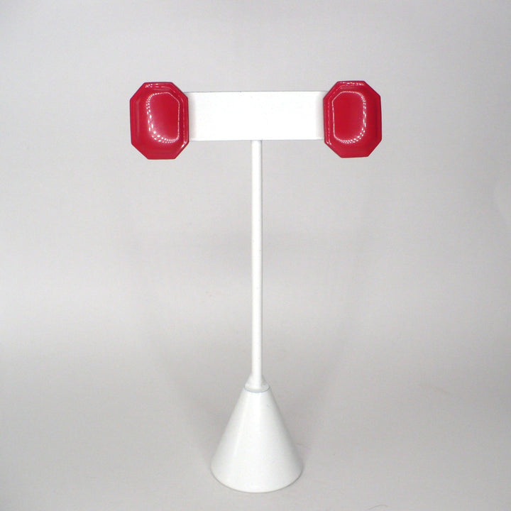 Front view of glossy octagonal pink acrylic stud earrings showcasing their vibrant finish and symmetrical shape.