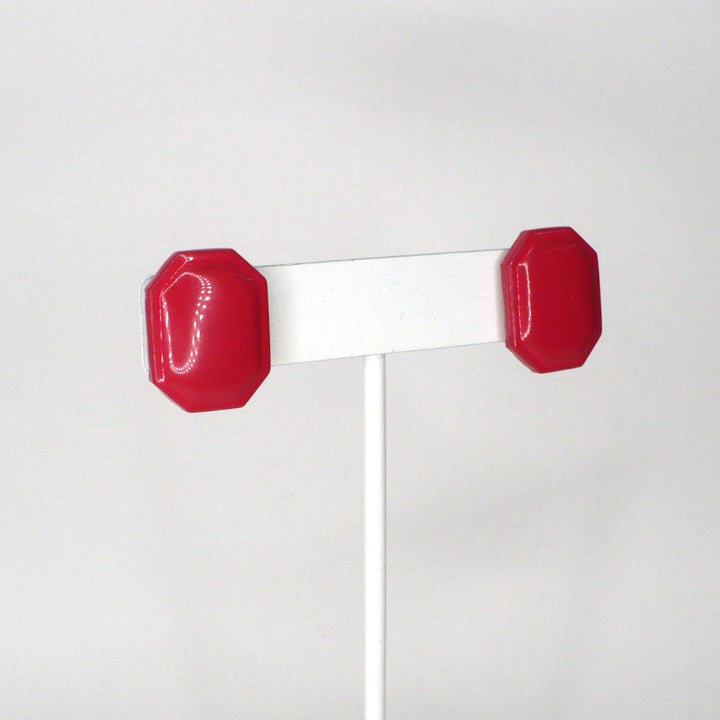 Pair of retro pink enamel statement earrings on a T-bar display.