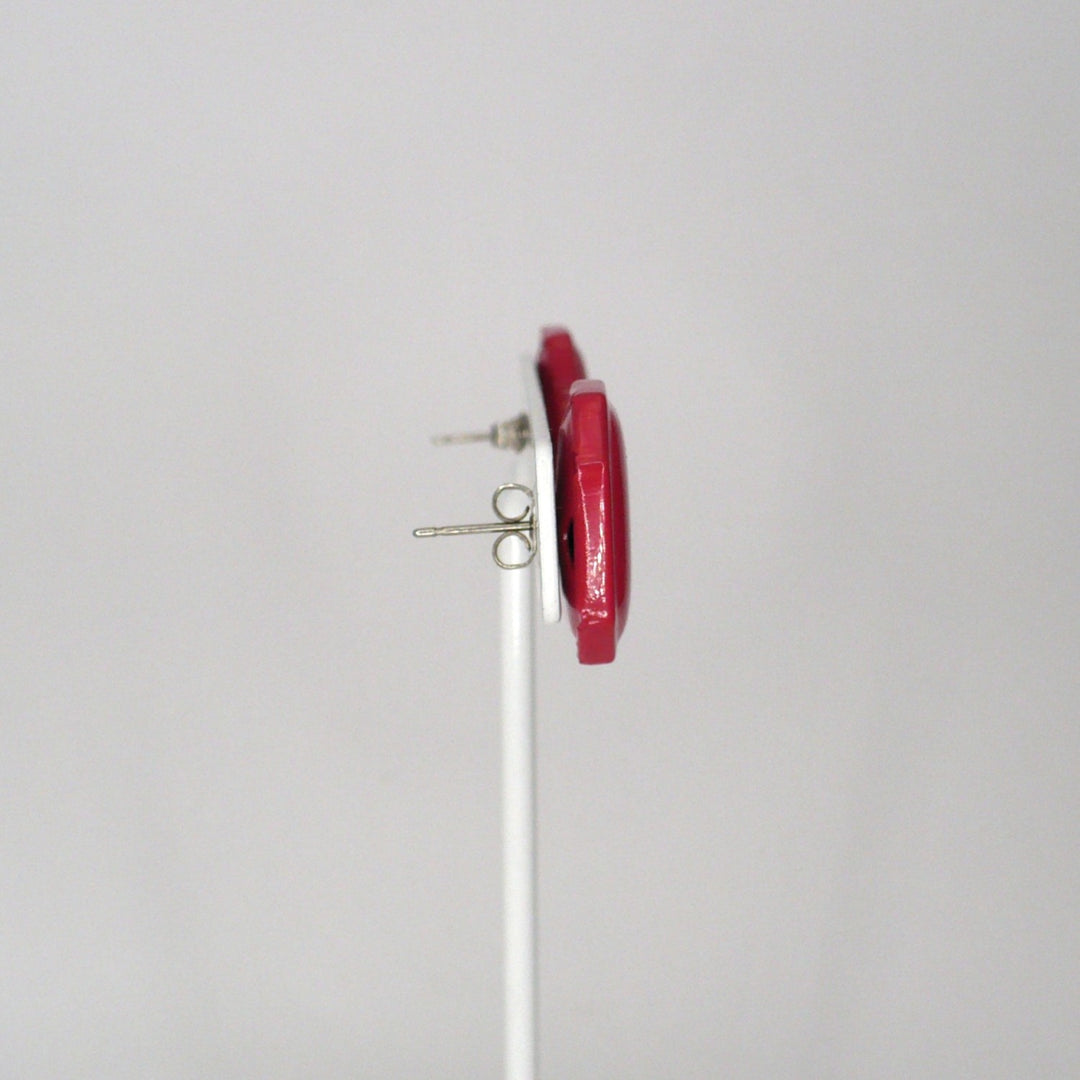 Pair of retro pink enamel statement earrings on a T-bar display shown side view.