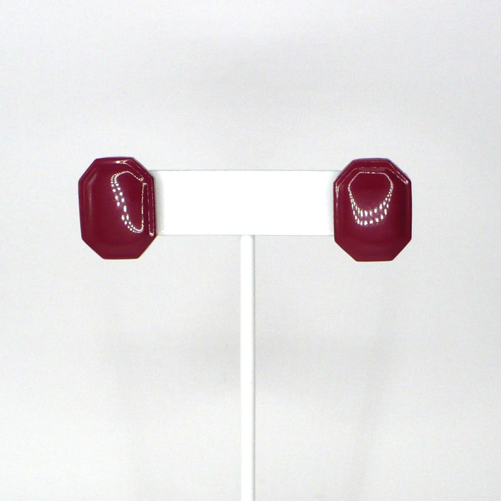 1980s vintage burgundy maroon emerald-cut enamel geometric button earrings on a white display stand.