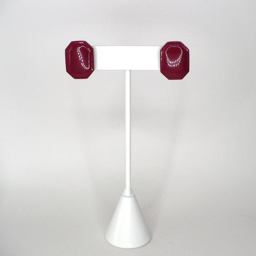 1980s vintage burgundy maroon emerald-cut enamel geometric button earrings on a white display stand facing front.