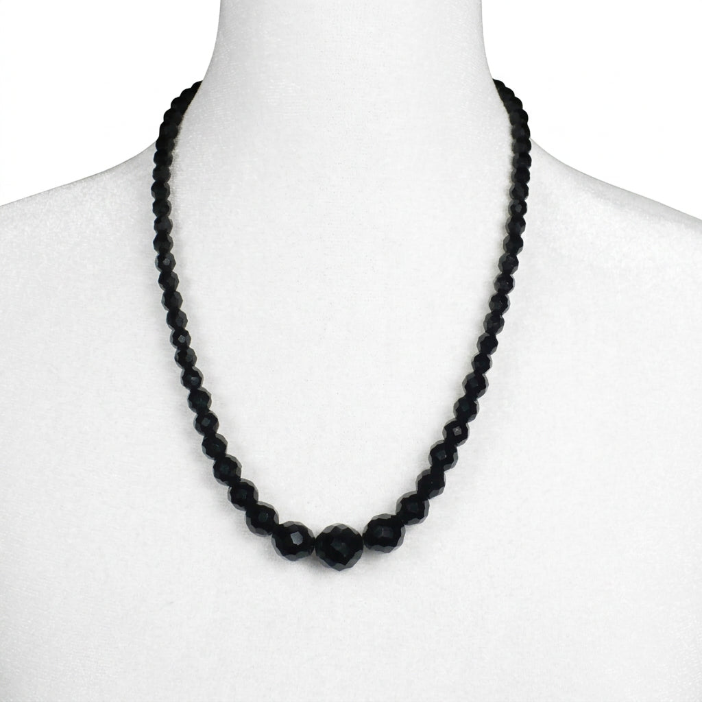 Close-up of a jewelry bust displaying the 1950s vintage black faceted glass beaded necklace.