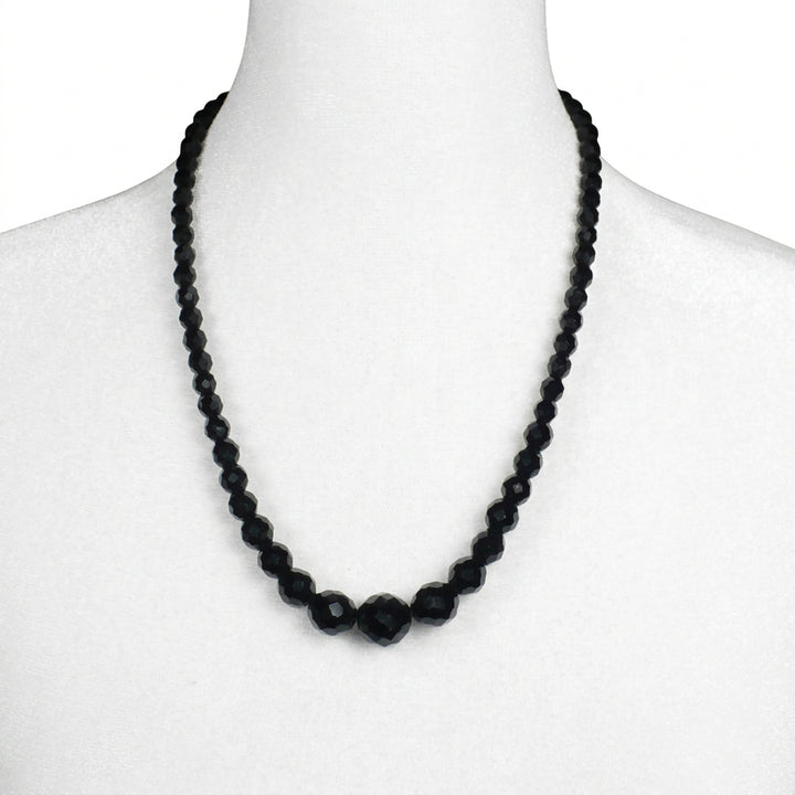 Close-up of a jewelry bust displaying the 1950s vintage black faceted glass beaded necklace.