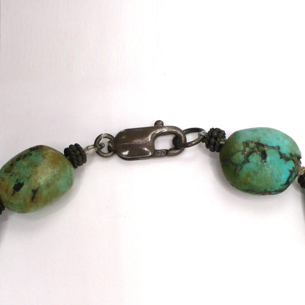 Close-up of the sterling silver lobster clasp and organic Hubei turquoise nugget beads on a 1970s vintage bohemian necklace.