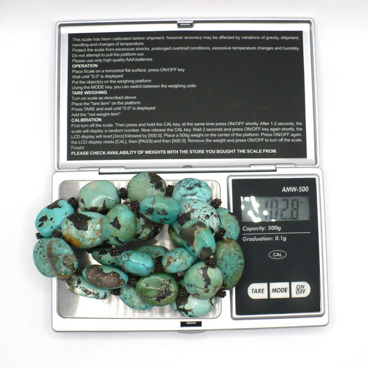 Digital scale displaying 102 grams for the 1970s vintage Hubei turquoise and sterling silver beaded necklace.