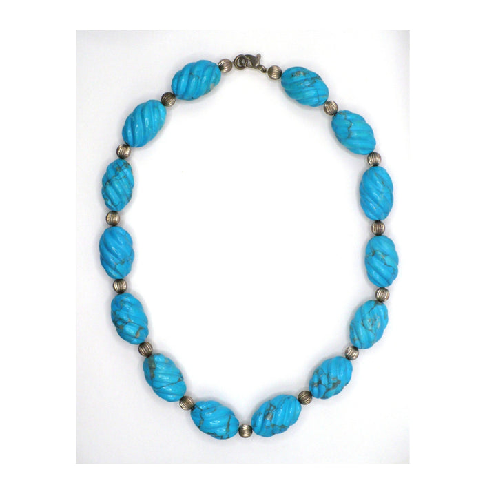 1970s vintage carved blue Howlite beaded necklace with round silver beads on a white background.