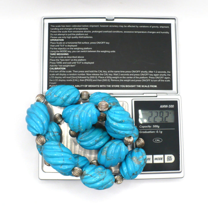 1970s vintage carved blue Howlite beaded necklace on a digital scale showing weight.