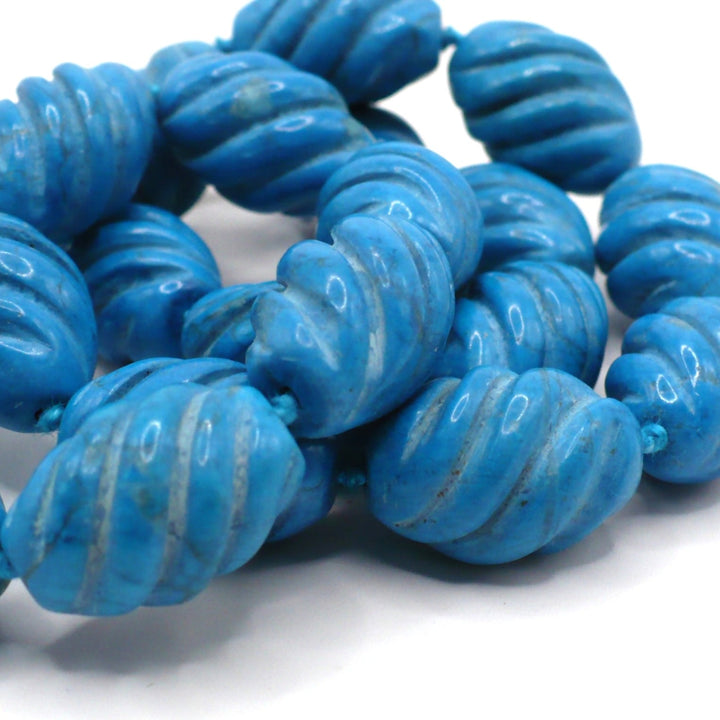 Close-up view of carved blue Howlite beads showing the detailed texture.