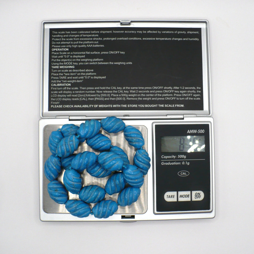 1970s vintage carved blue Howlite beaded necklace on a digital scale showing weight.
