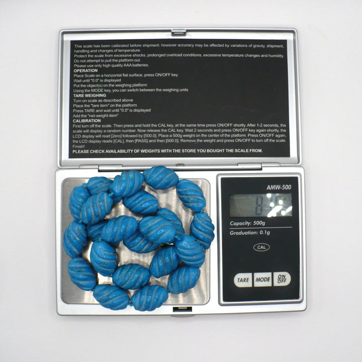1970s vintage carved blue Howlite beaded necklace on a digital scale showing weight.