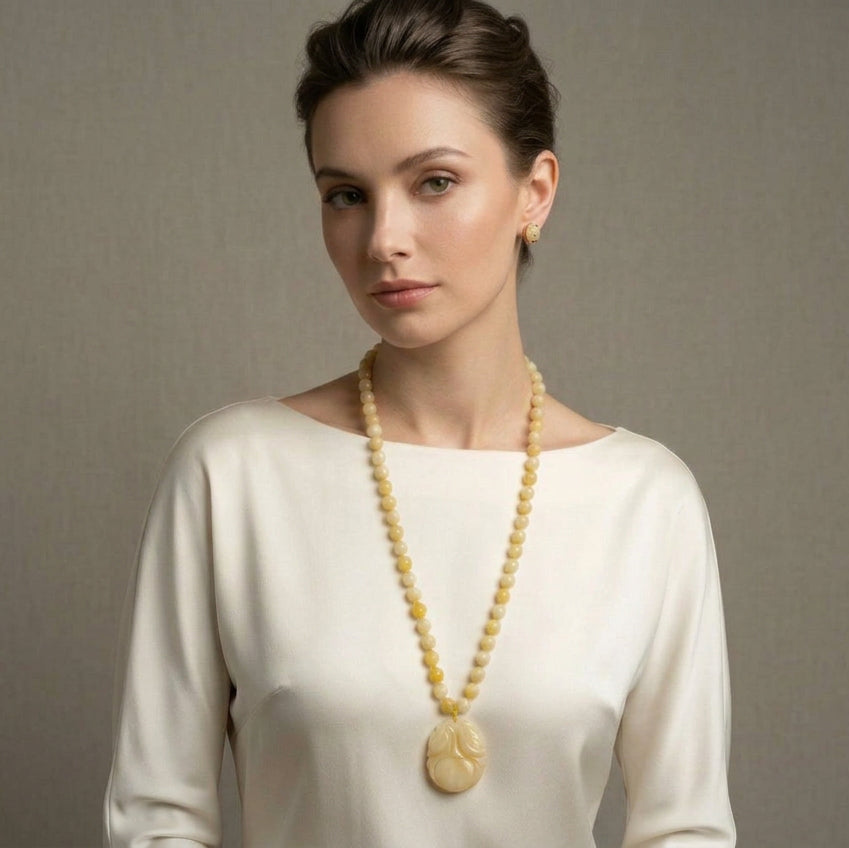 Woman wearing the vintage 1970s yellow nephrite jade beaded necklace with a hand-carved persimmon pendant.