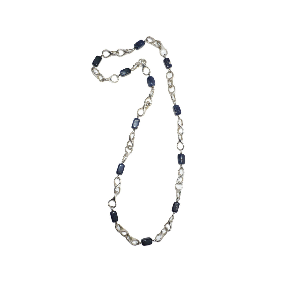 1970s vintage modernist sterling silver and blue sodalite station necklace laid flat.