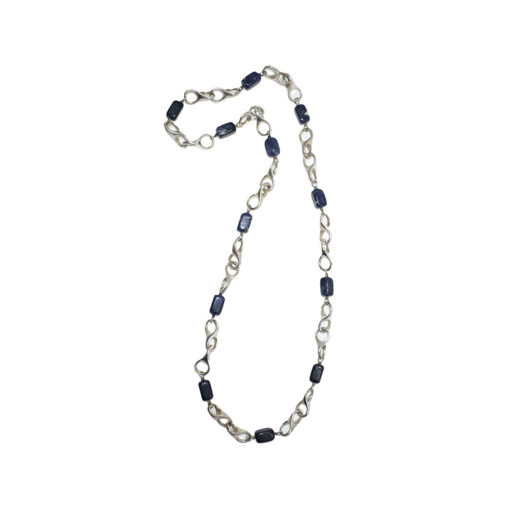 1970s vintage modernist sterling silver and blue sodalite station necklace laid flat.