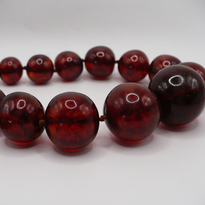 Rich cluster of vintage Baltic cherry amber beads showcasing organic luster and deep hues,