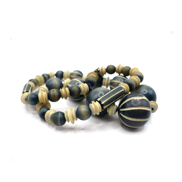 1970s vintage beaded necklace featuring blue-grey and cream striped wood beads and carved camel bone spacers.