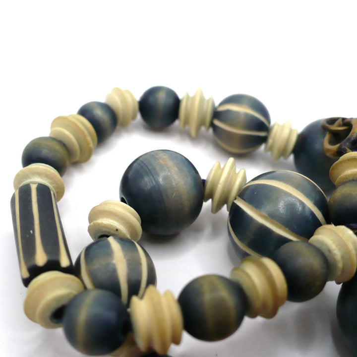 1970s vintage beaded necklace featuring blue-grey and cream striped wood beads and carved camel bone spacers.