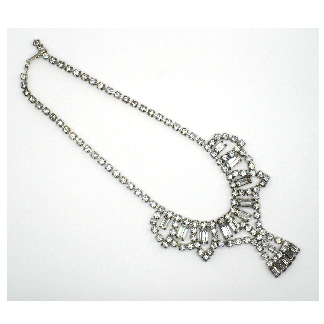 Signed Lisner 1950s vintage rhinestone festoon necklace laid flat, showing silver-tone crystal collar and mixed-cut stones.