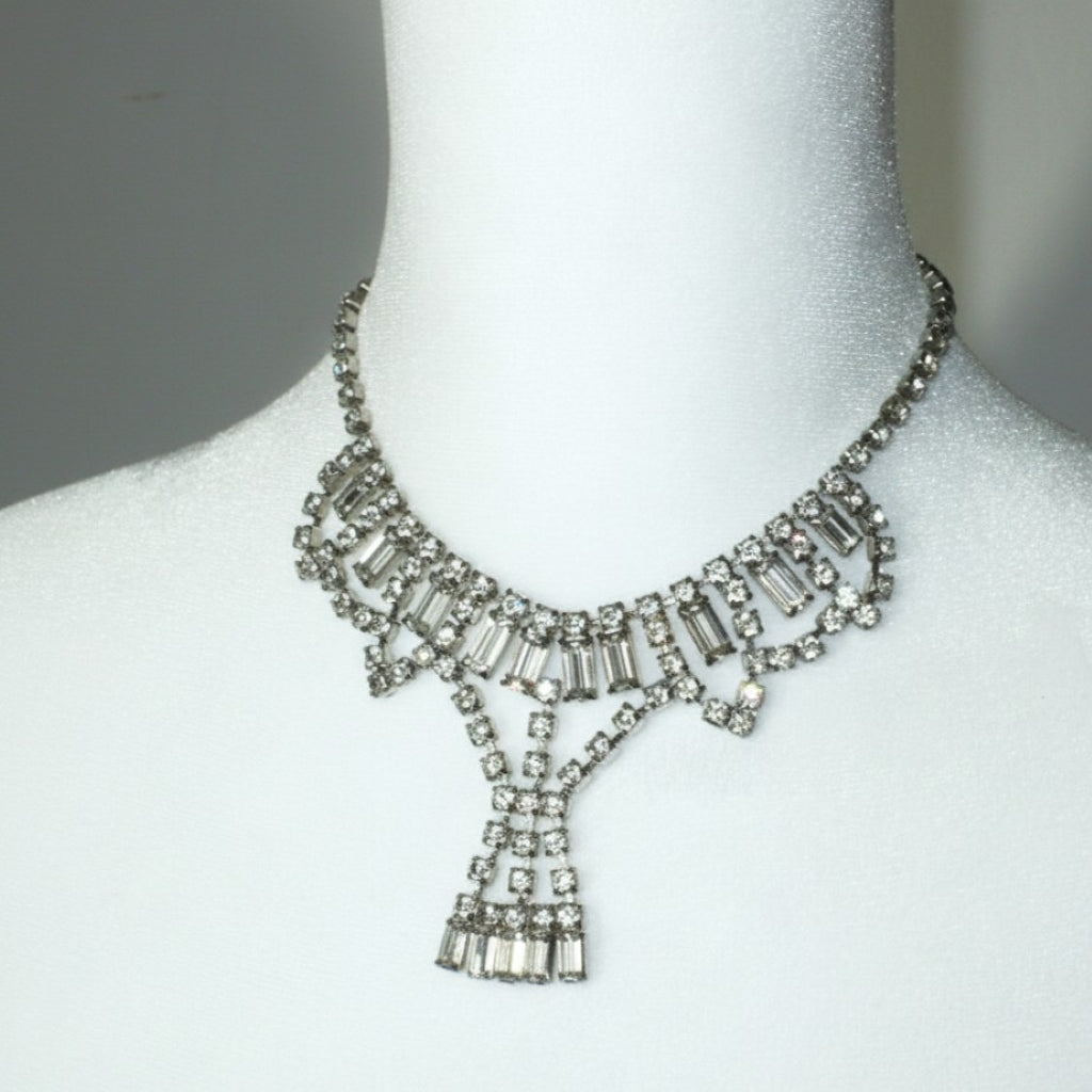 Signed vintage Lisner rhinestone festoon necklace detail view showing crystal pendant drop on a mannequin.