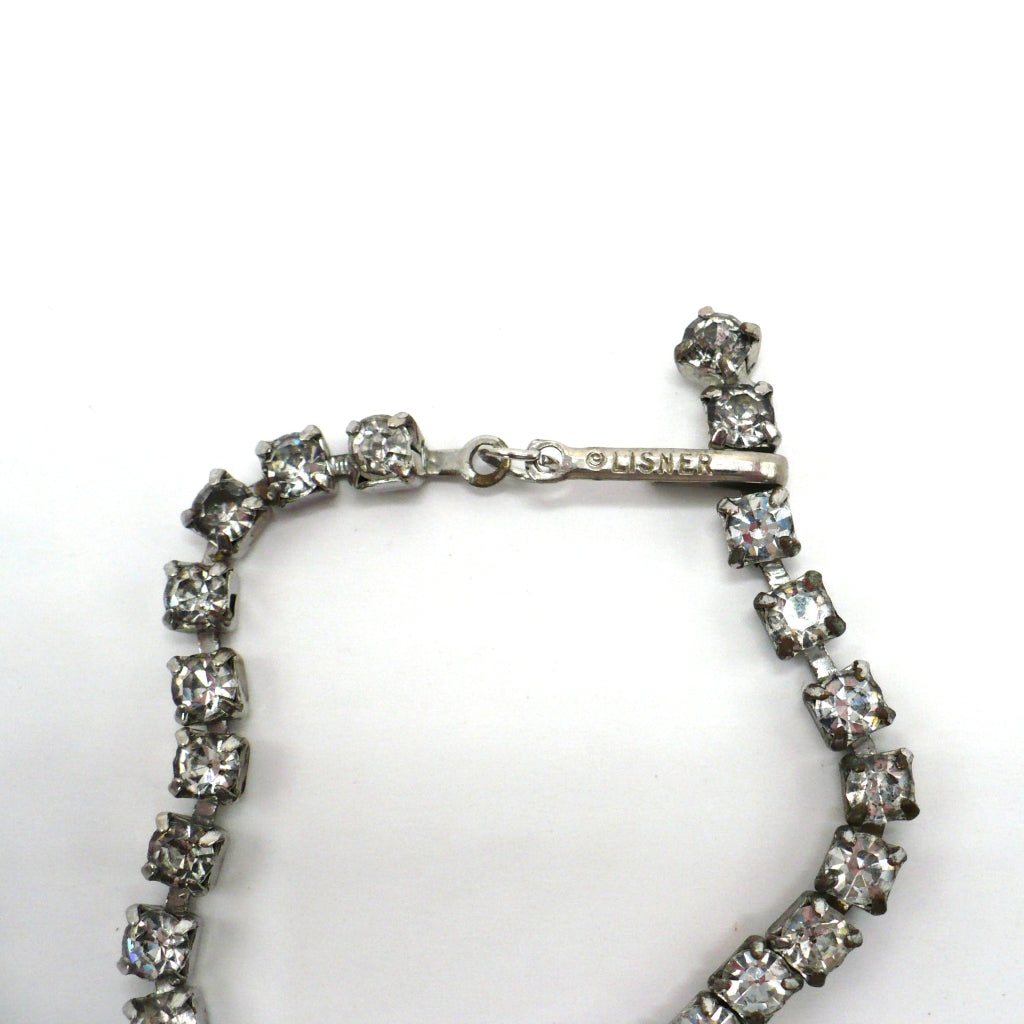 Signed vintage Lisner rhinestone festoon necklace close-up view showing the hook clasp and maker's hallmark stamp.